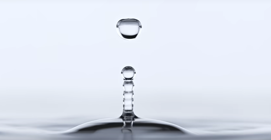 Drop Of Water Demonstrating Physics Of Lensing Effect That Inspires Liquid Glass